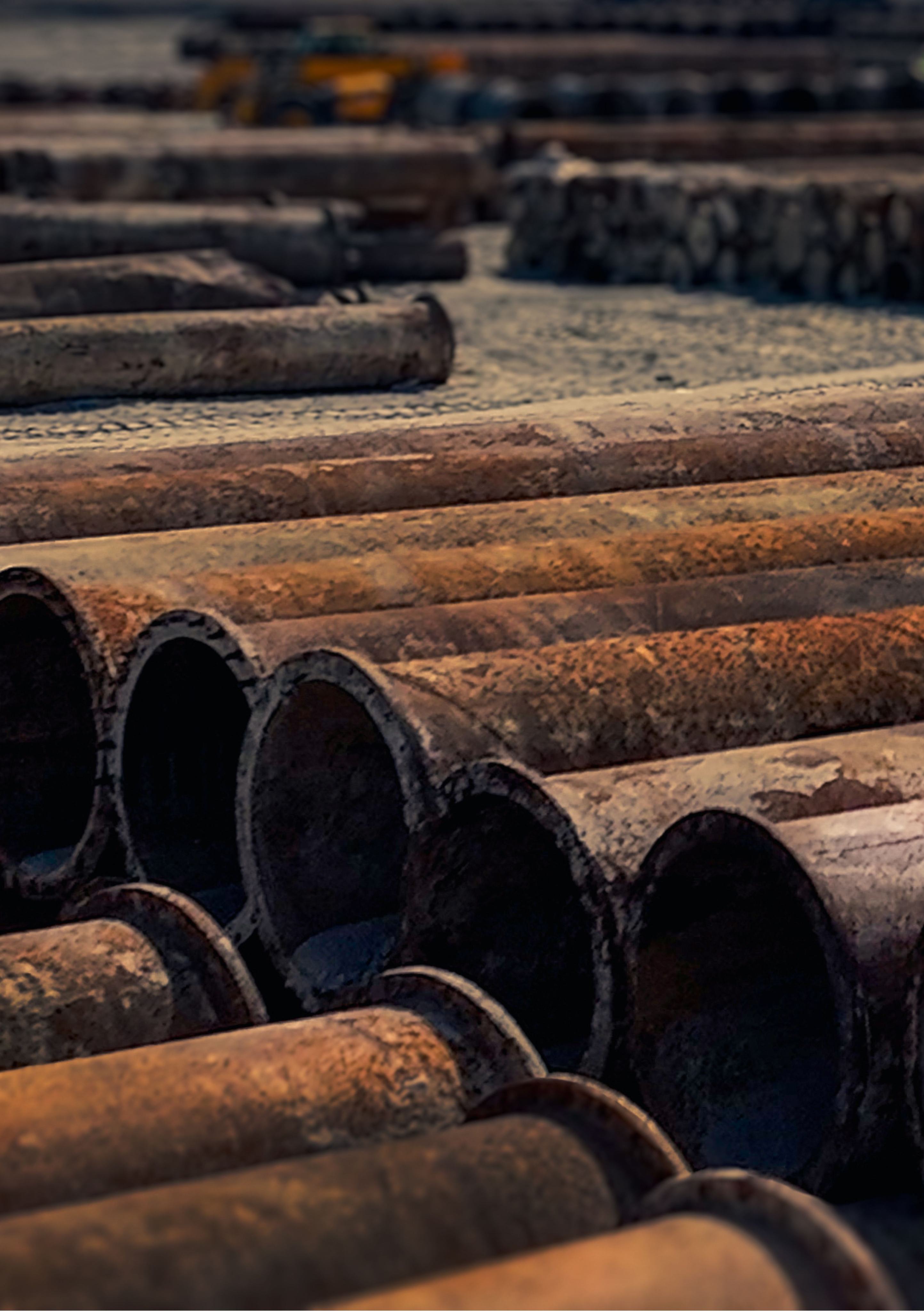 Coated pipe sections stacked in an industrial yard